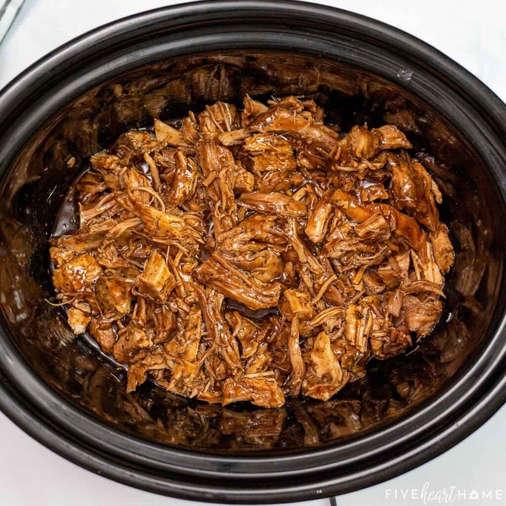 Adding bbq sauce to pulled pork in root beer.