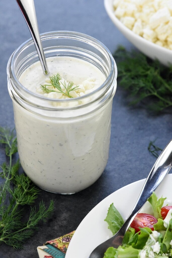 Creamy Feta Dressing recipe in jar with dill on top.