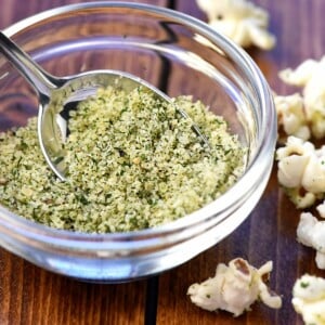 Ranch Popcorn Seasoning in small glass bowl with spoon.