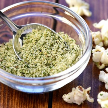 Ranch Popcorn Seasoning in small glass bowl with spoon.