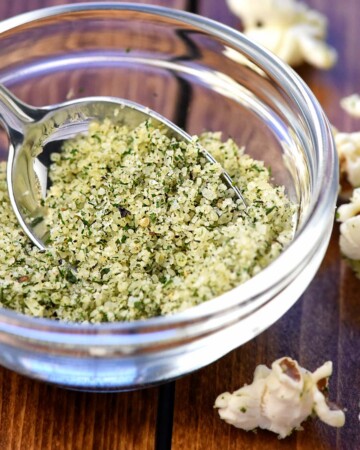 Ranch Popcorn Seasoning in small glass bowl with spoon.