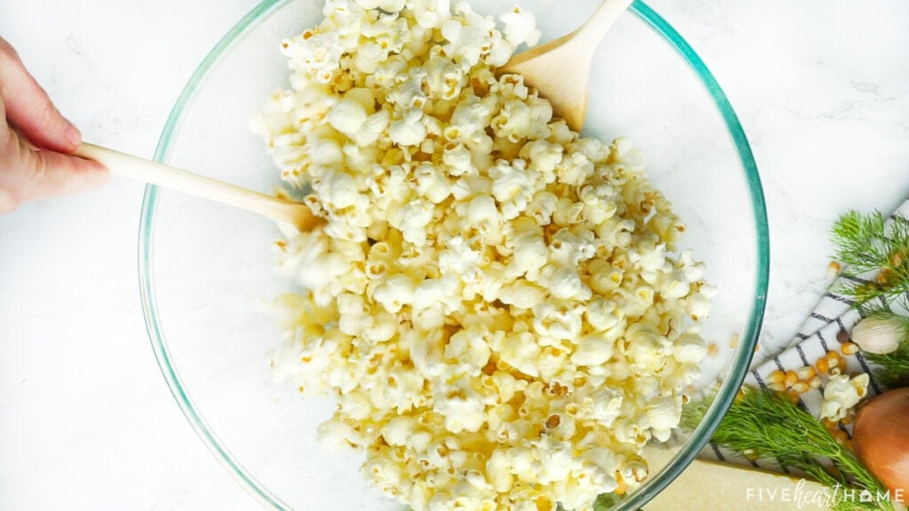 Tossing butter into popcorn.