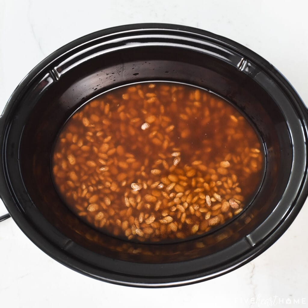 Charro Bean recipe in slow cooker with broth on top.