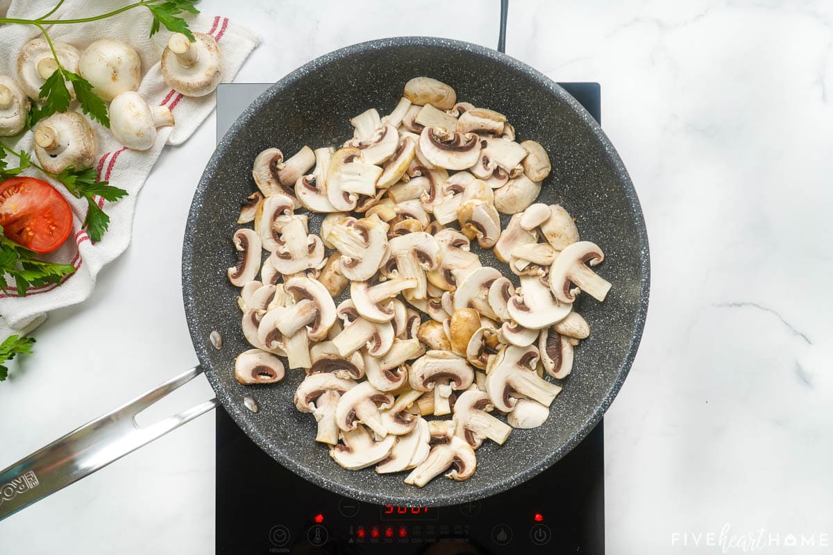 Sauteing mushrooms in skillet to make mushroom gravy for hamburger steak.