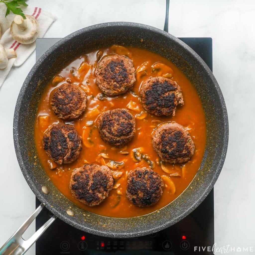 Hamburger Steak with Mushroom Gravy in skillet.