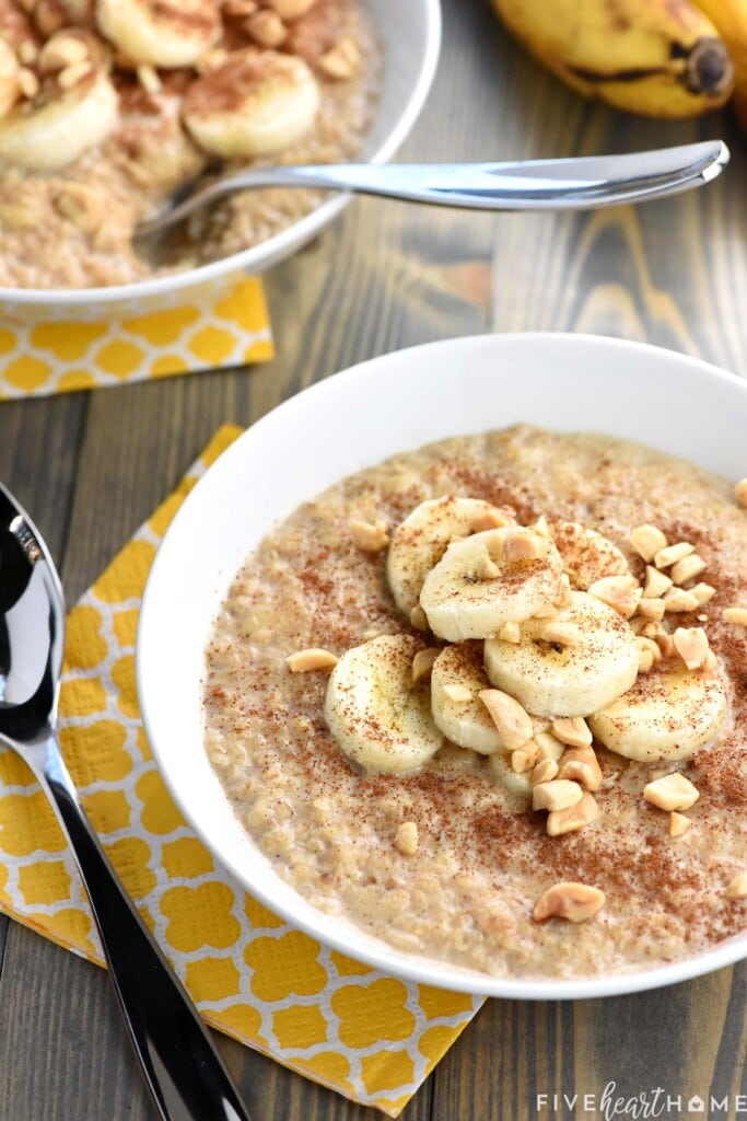 Two bowls of banana oatmeal with spoons.