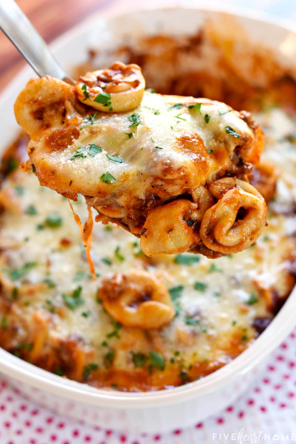 Baked Tortellini being scooped out of dish.