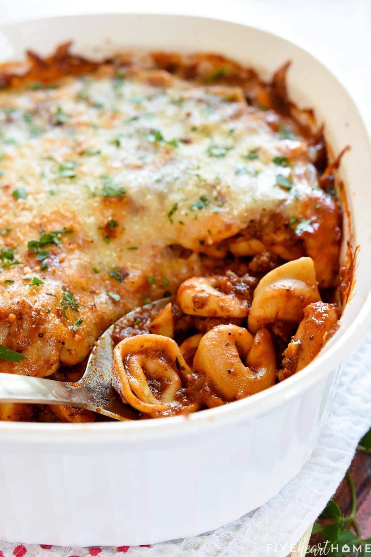 Beef Tortellini being scooped out of baking dish.