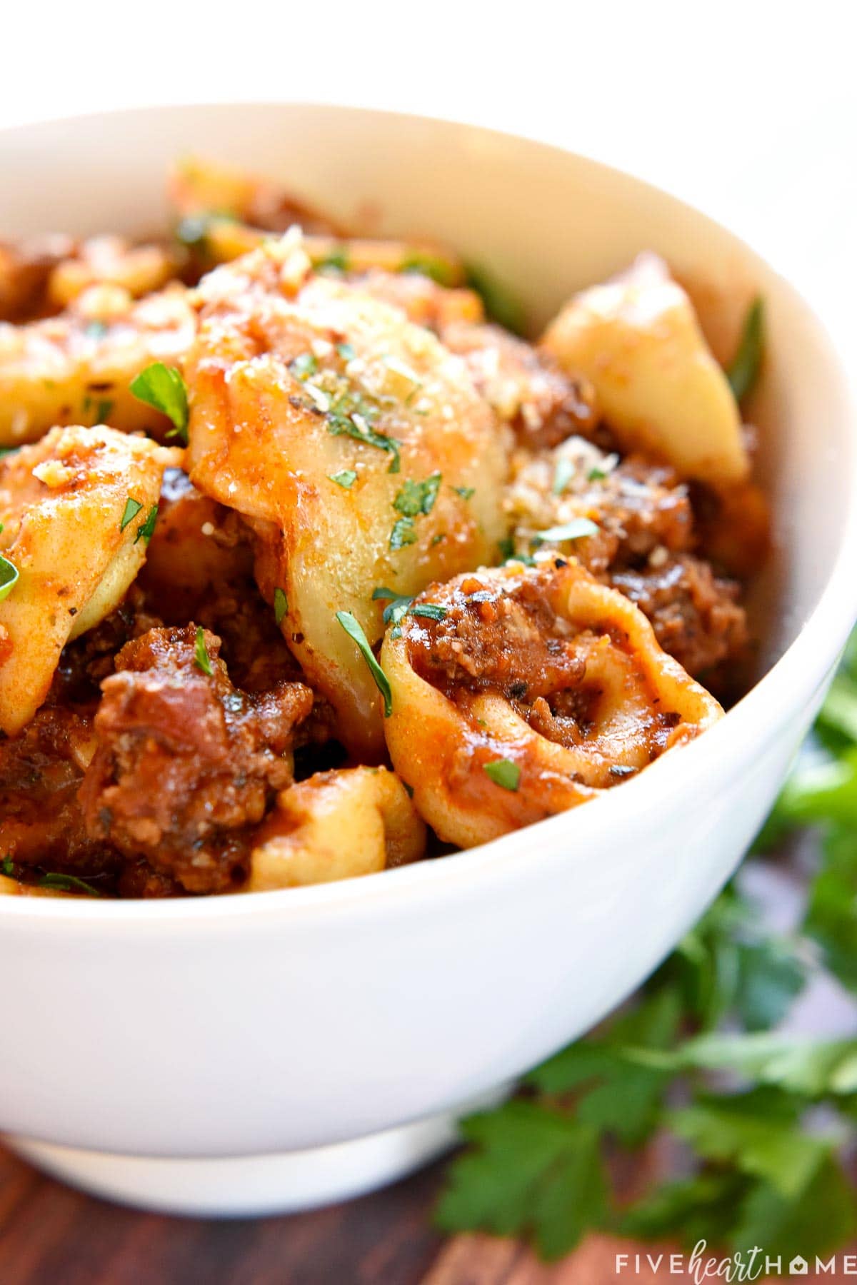 Baked Tortellini with ground beef in bowl.