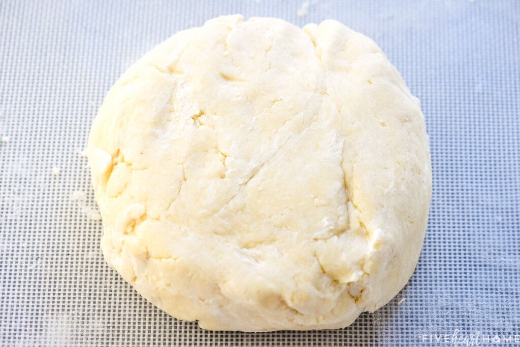 Patting pie crust recipe butter into a disk.
