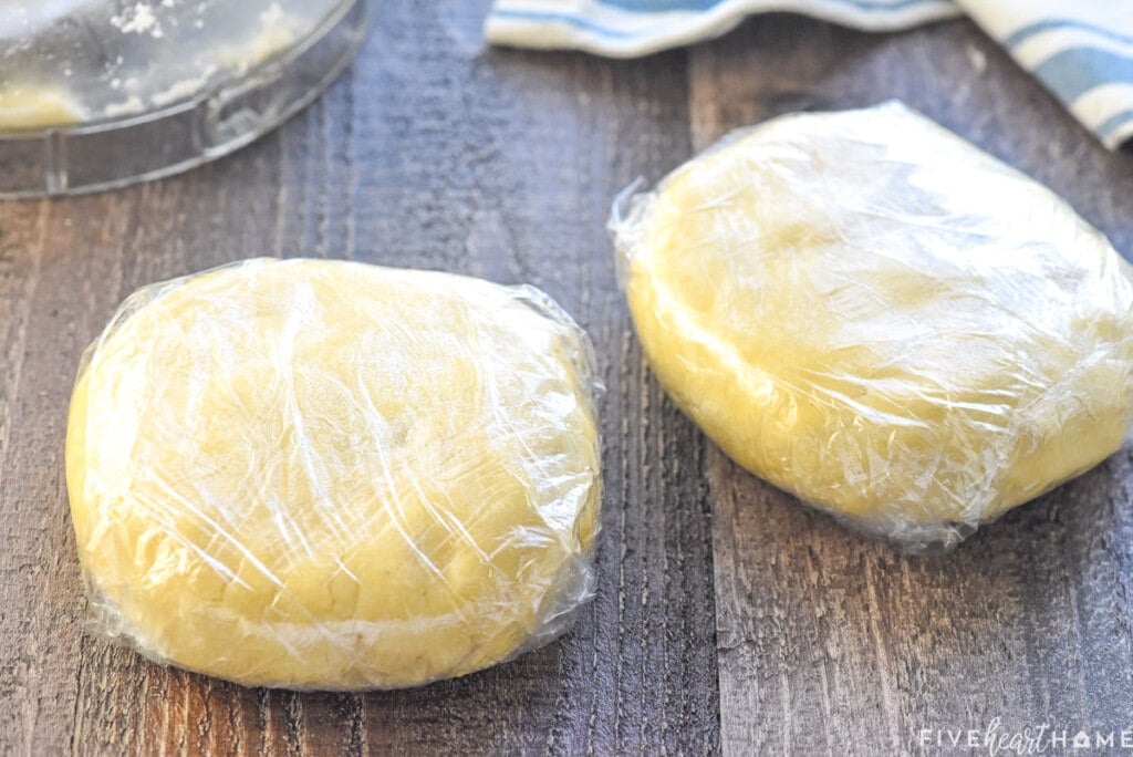 Pie crust with butter disks wrapped in plastic wrap.