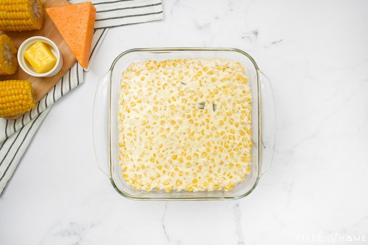 Corn casserole with cream cheese in baking dish.
