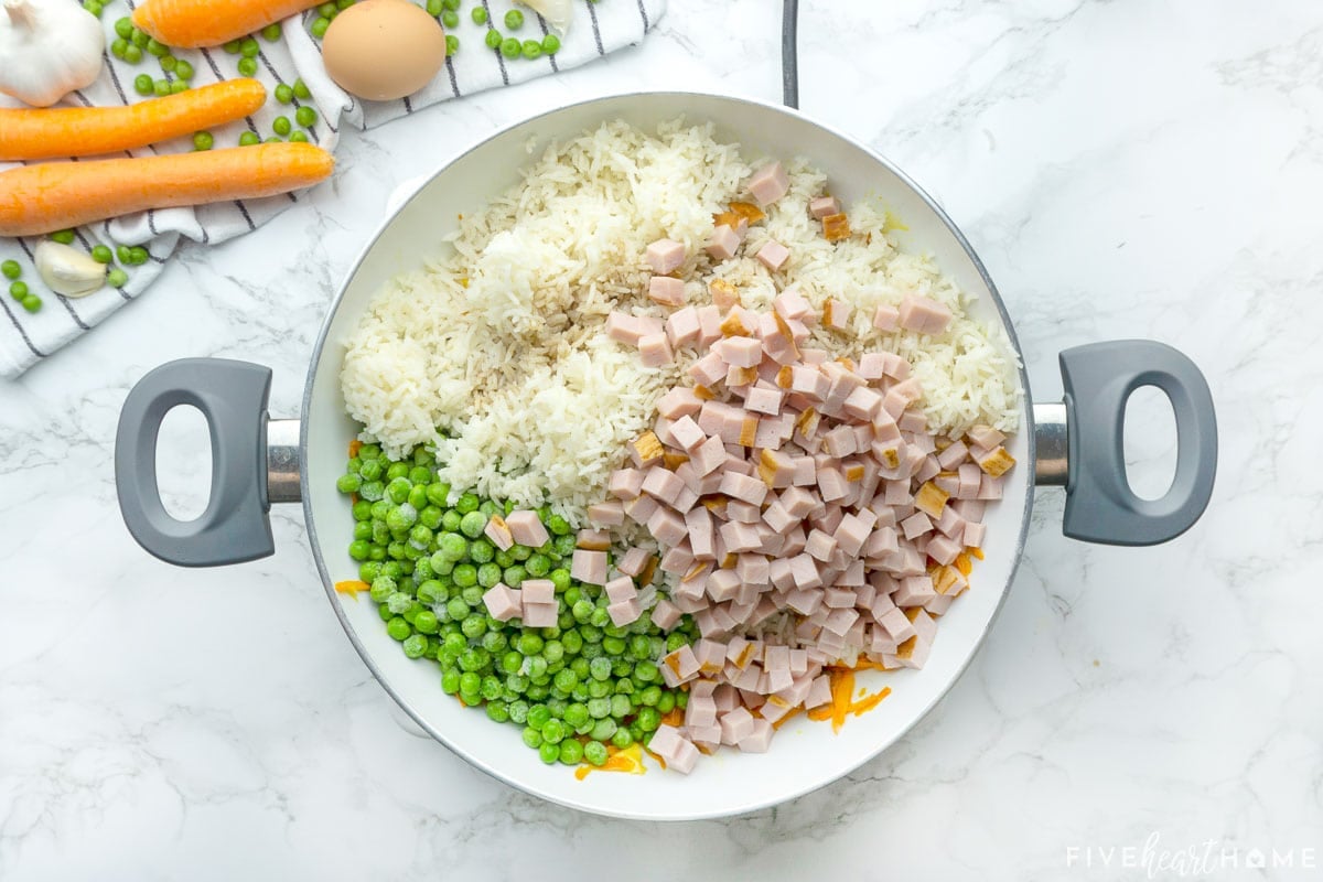 How to make fried rice by adding rice, peas, and diced ham to the pan.