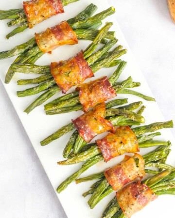 Aerial view of Green Bean Bundles lined up on white platter.
