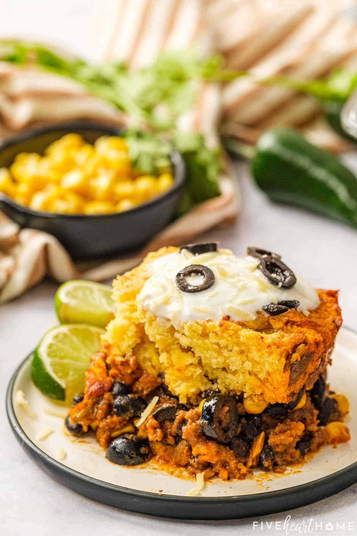 Mexican Cornbread Casserole on plate with lime wedges.