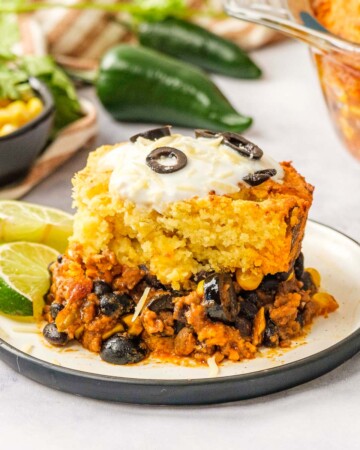 Mexican Cornbread Casserole on plate with limes.