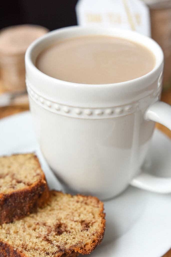 Vanilla chai tea in mug with quick bread on plate.
