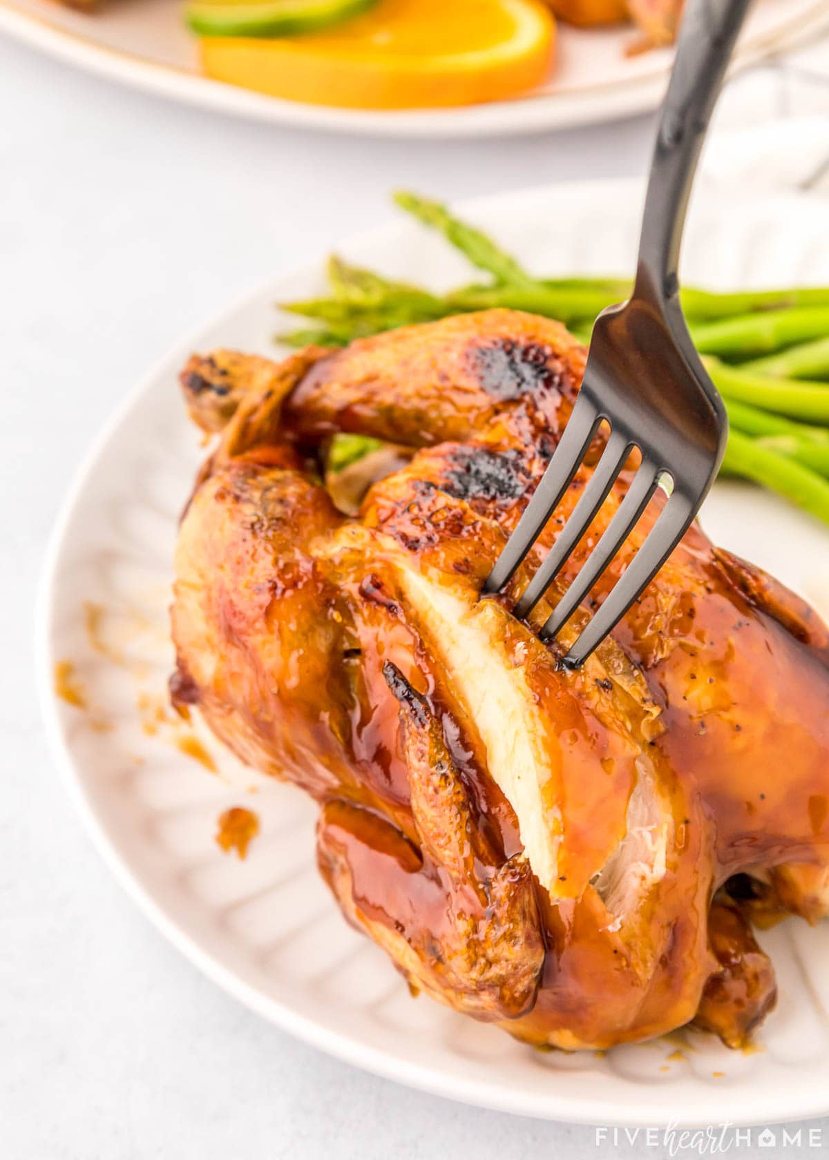 Slicing into Cornish hen on plate.