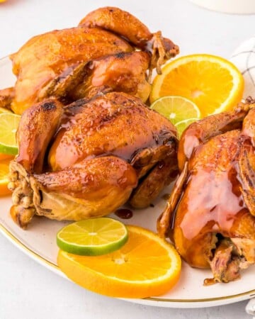 Cornish hen recipe with citrus glaze on platter.