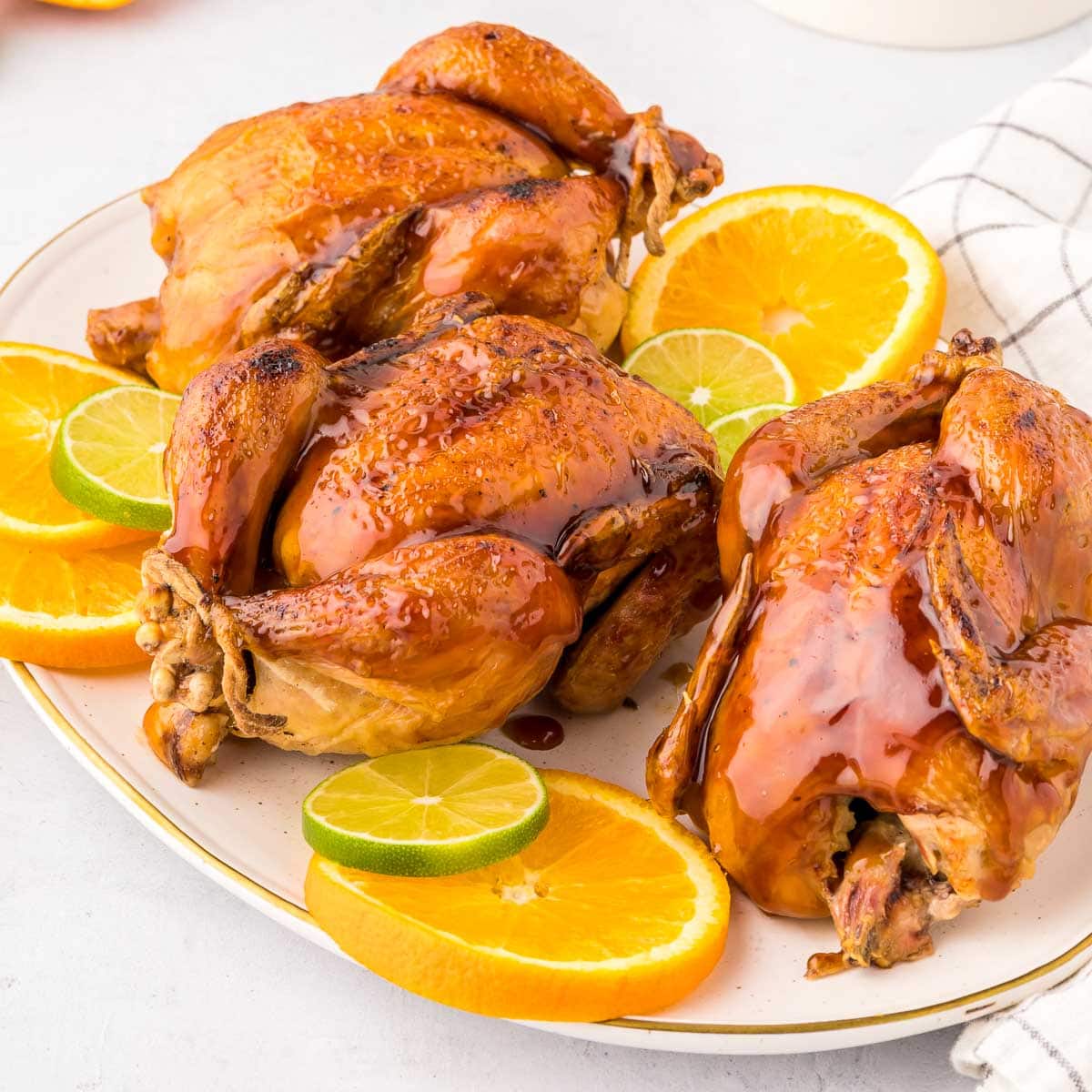 Cornish hen recipe with citrus glaze on platter.