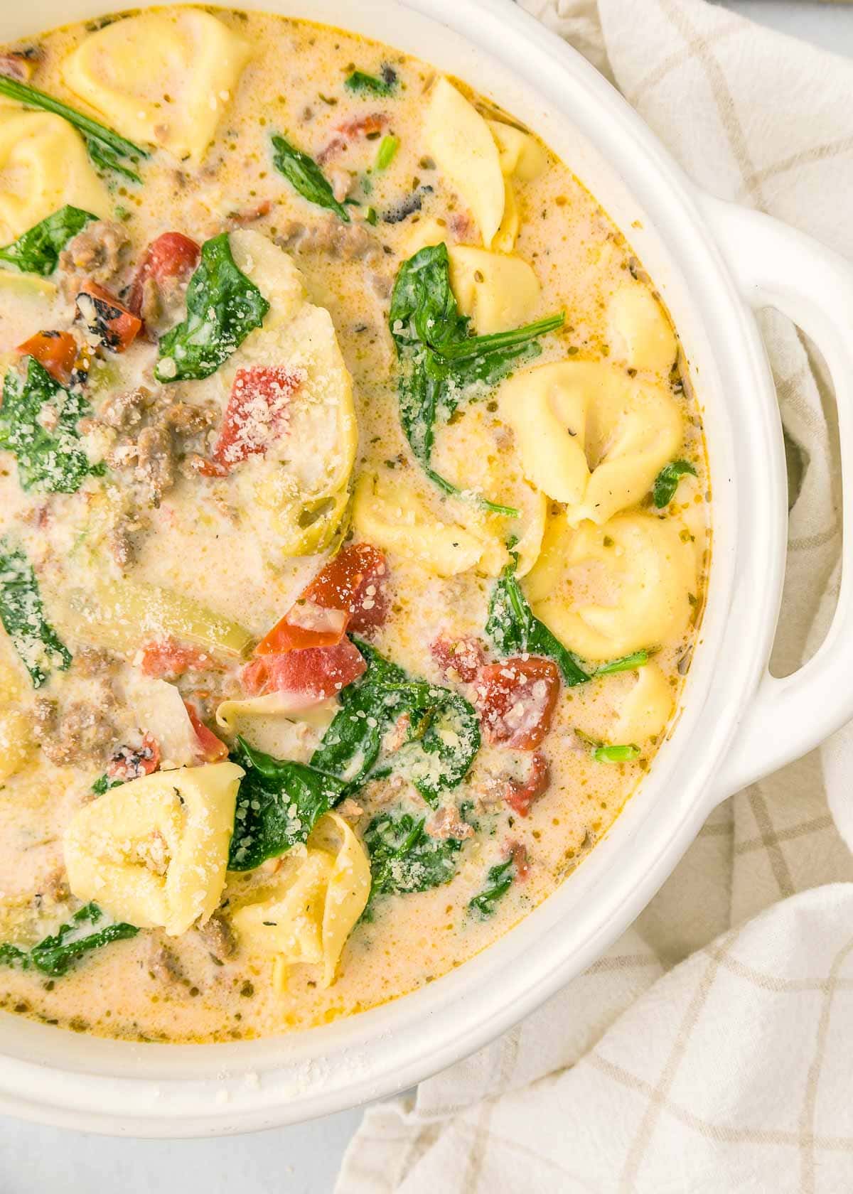 Sausage Tortellini Soup showing creamy broth and baby spinach.