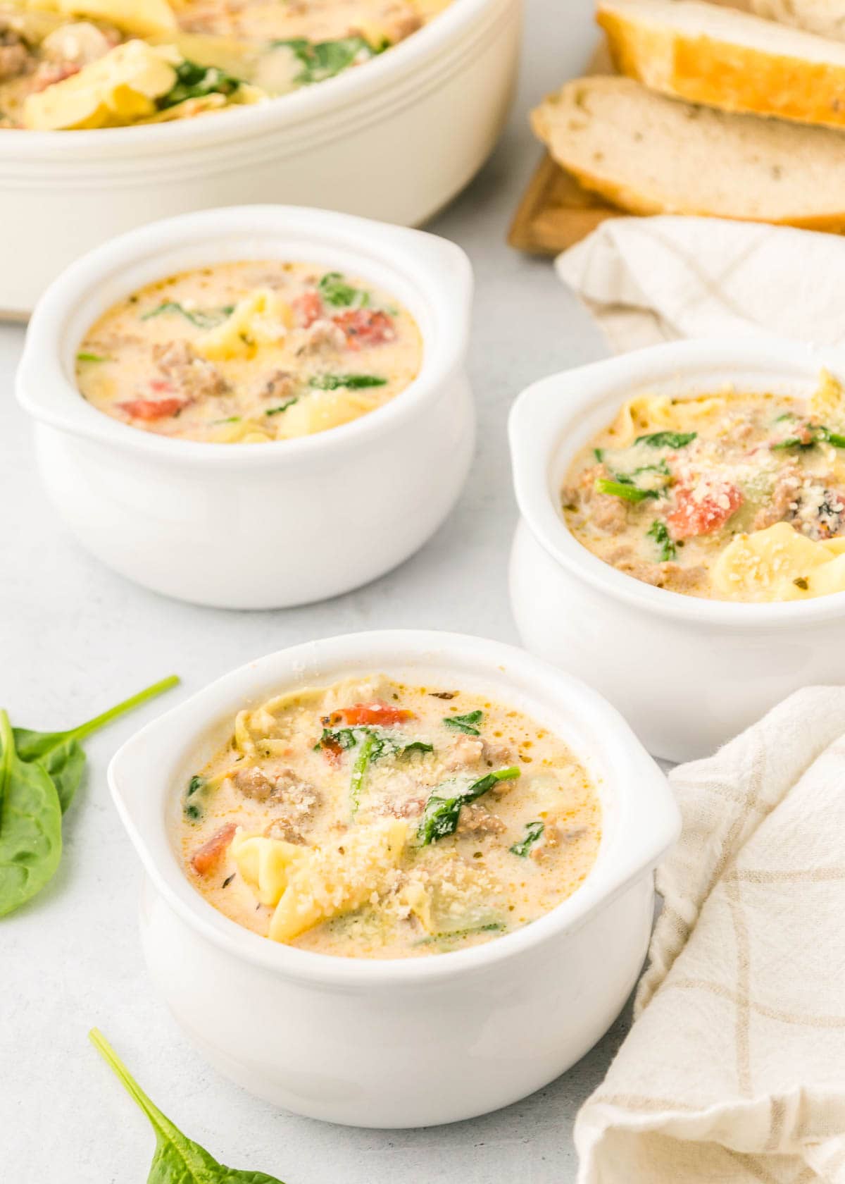 Sausage Tortellini Soup in bowls with pot in background.