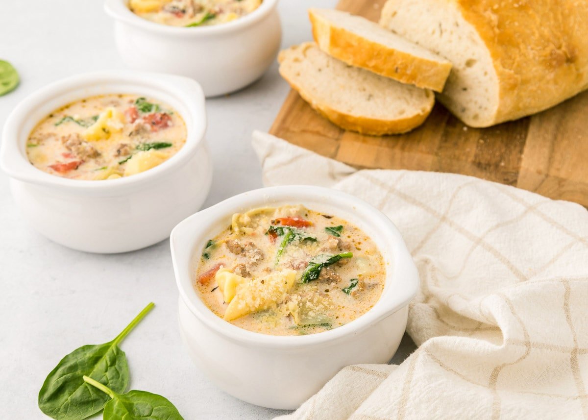 Creamy Sausage Tortellini Soup in bowls with bread.
