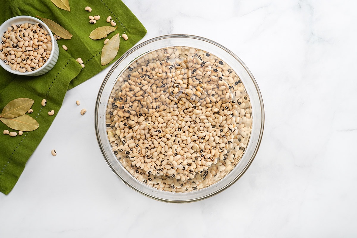 Bowl of dried black eyed peas soaking in water.