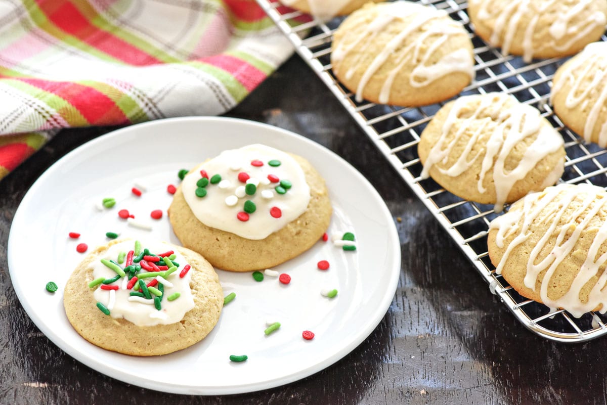 Eggnog Cookies on plate and cooling rack with eggnog glaze either spooned or drizzled.