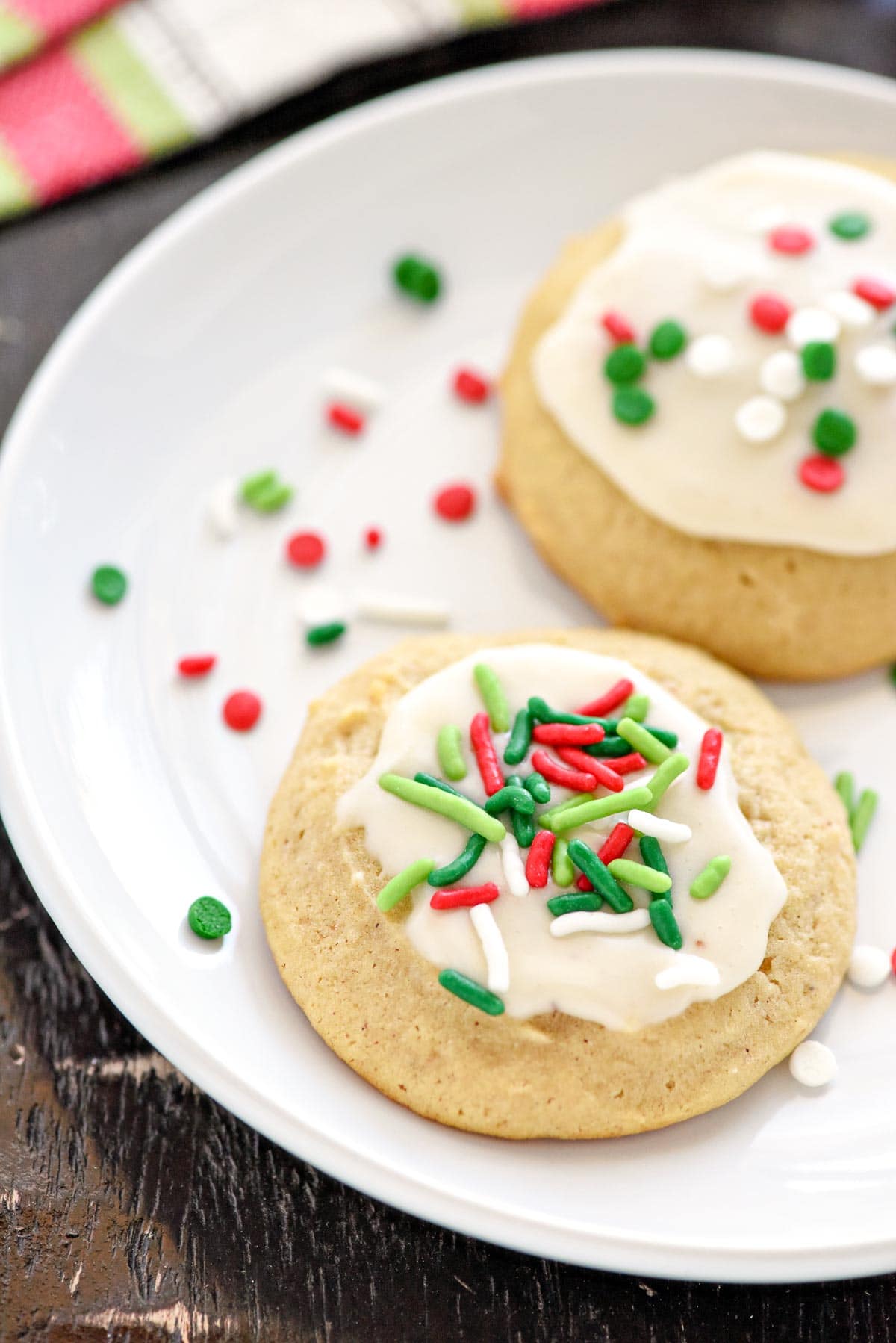 Close-up of Eggnog Cookies on plate with eggnog glaze and sprinkles.