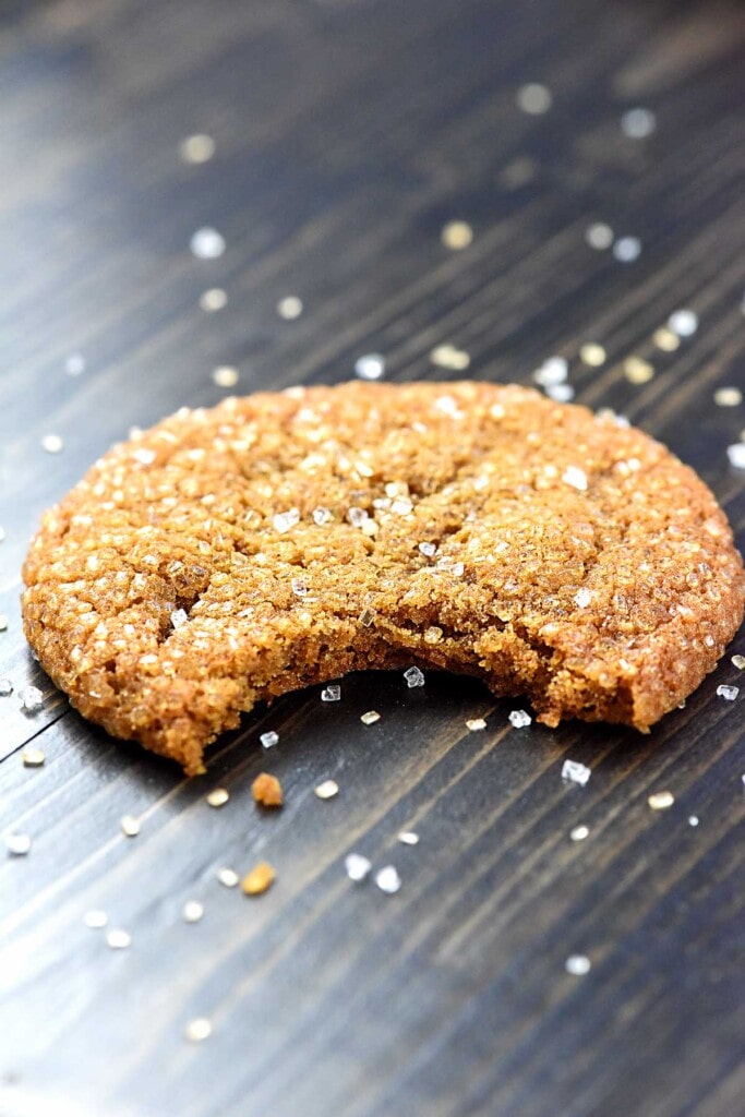 Molasses Ginger Cookies with sparkling sugar and missing bite.