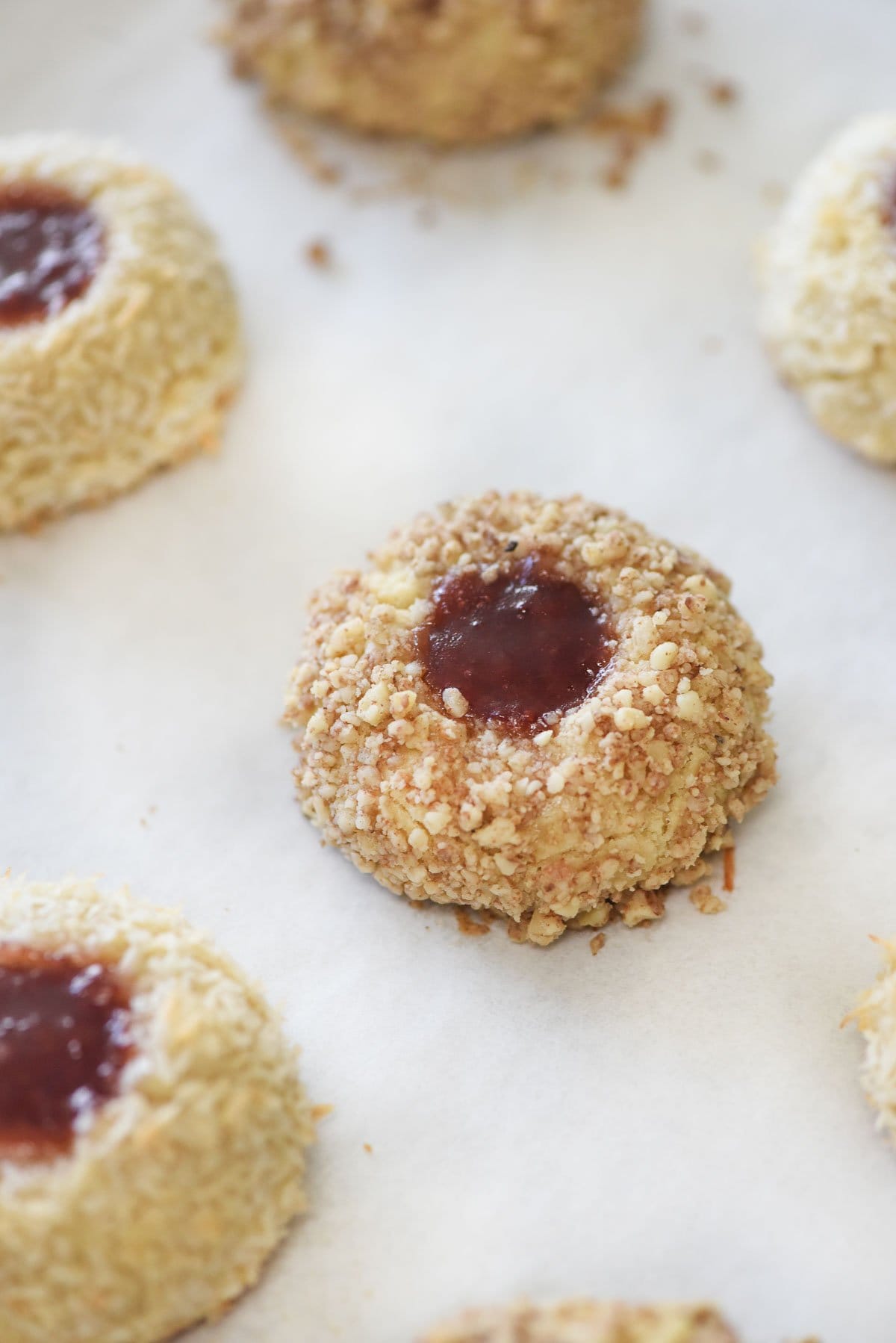 Jam Thumbprint Cookies baked on parchment paper.