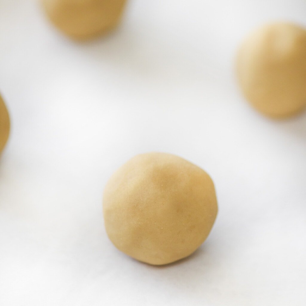 Rolling raspberry thumbprint cookies into balls.