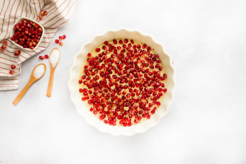 Sprinkling Pomegranate Cake with pomegranate seeds.