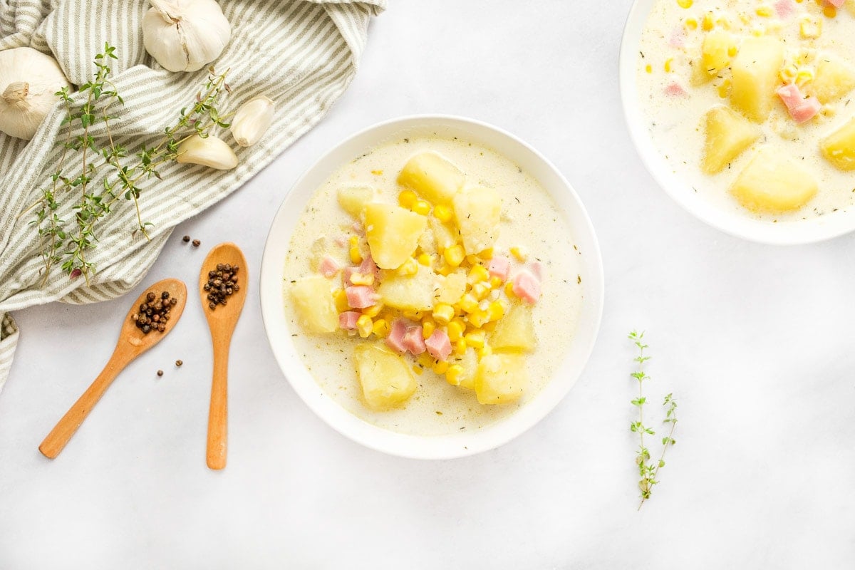 Bowls of Potato Corn Chowder on white table.