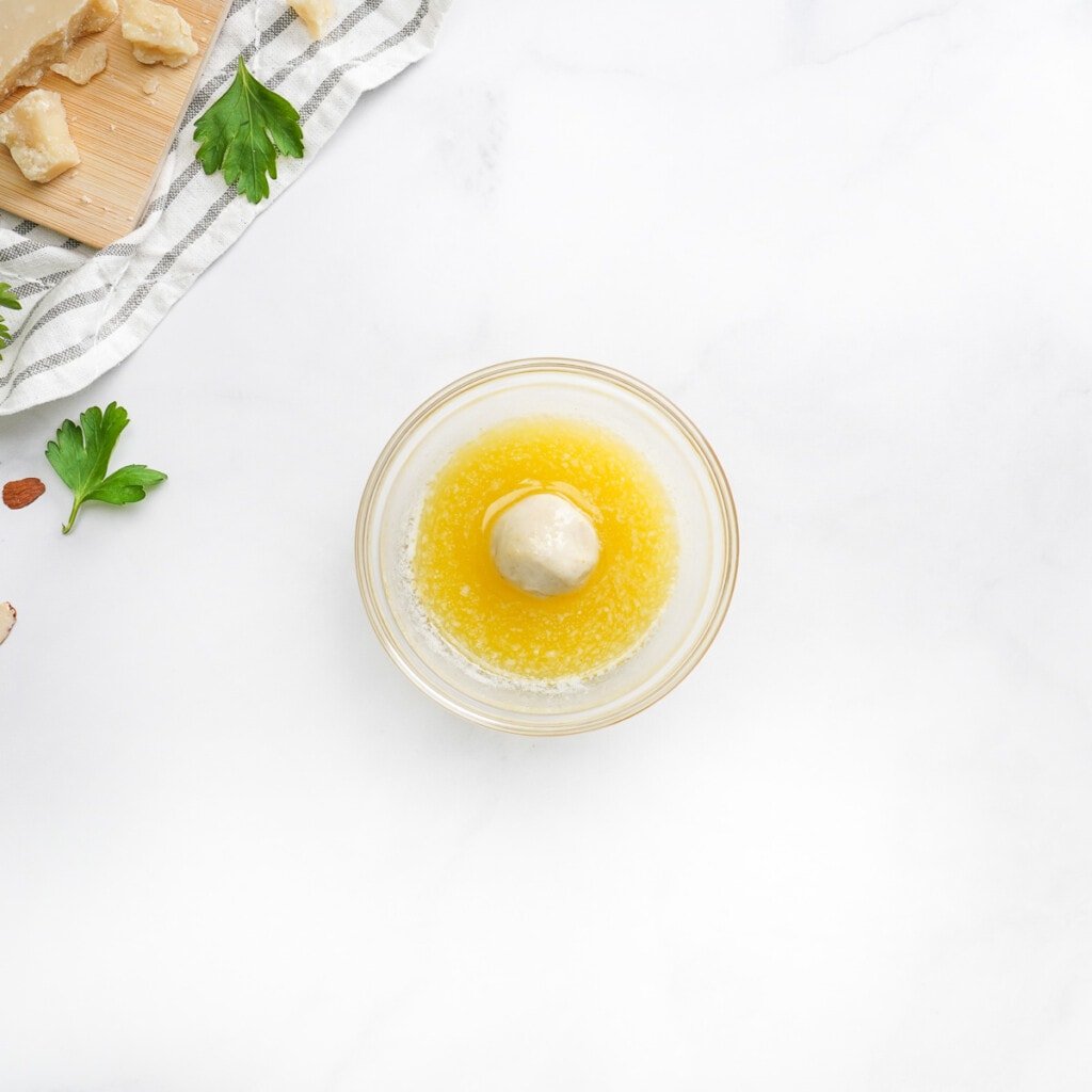 Coating biscuit ball in butter.