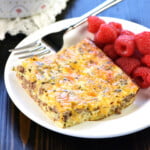 Ground Beef and Egg Breakfast Casserole slice on plate with raspberries.