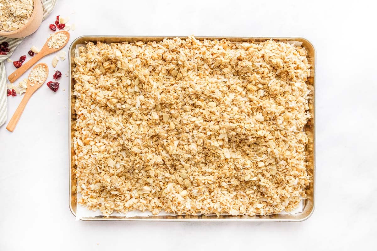 Spreading Homemade Granola on pan.