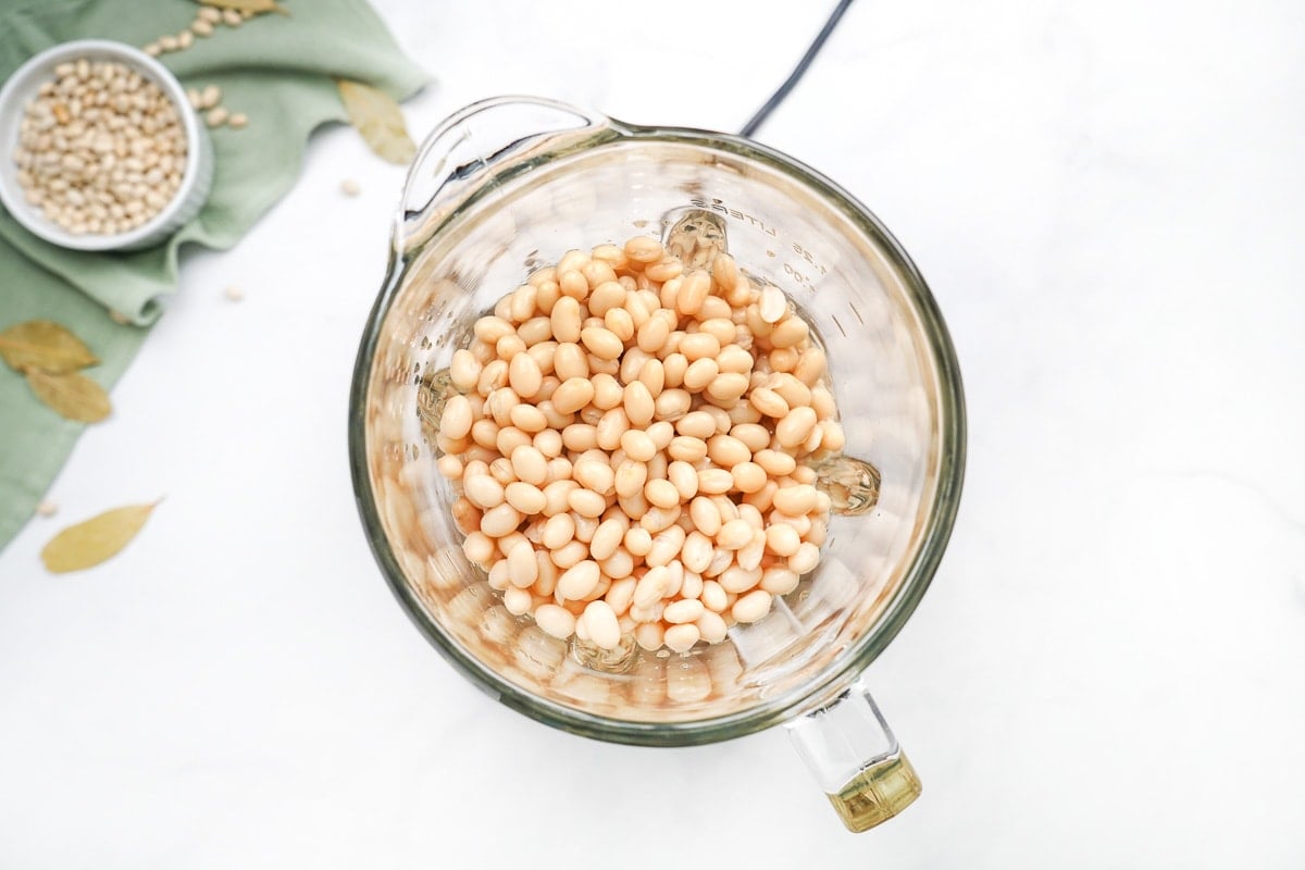 Pureeing beans in blender to make white bean and kale soup.