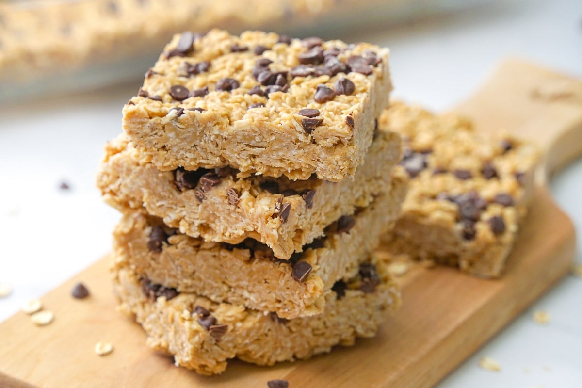 Chewy Granola Bars stacked on wooden board.