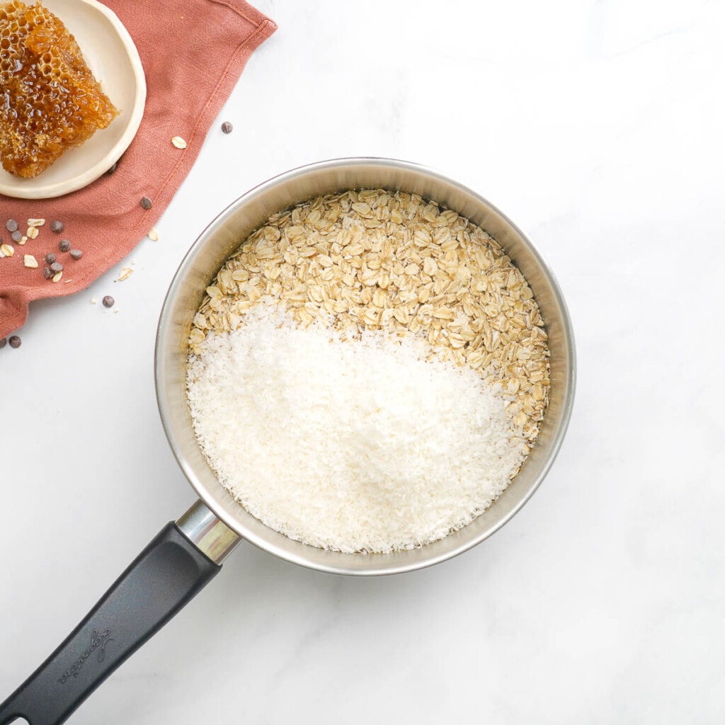 Adding oats and coconut to pot.