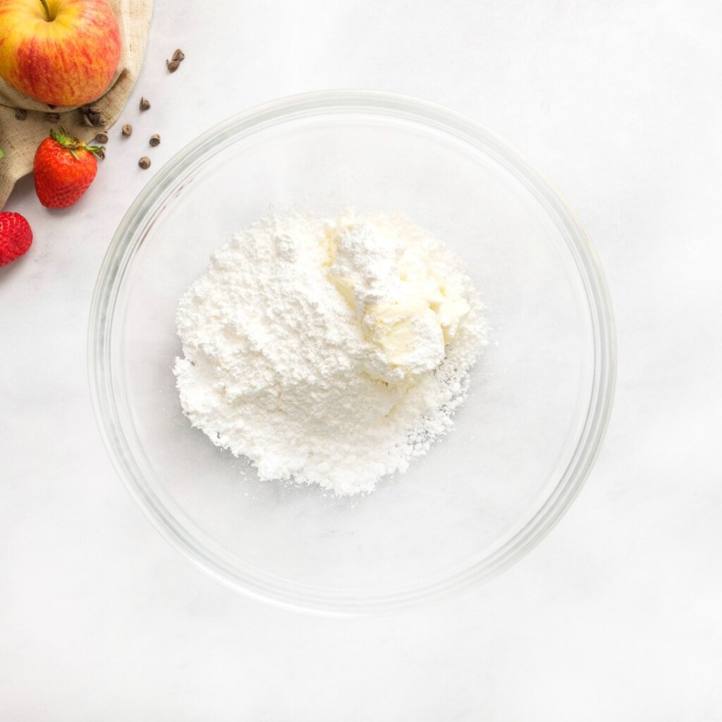 Adding powdered sugar to cream cheese for chocolate fruit dip.