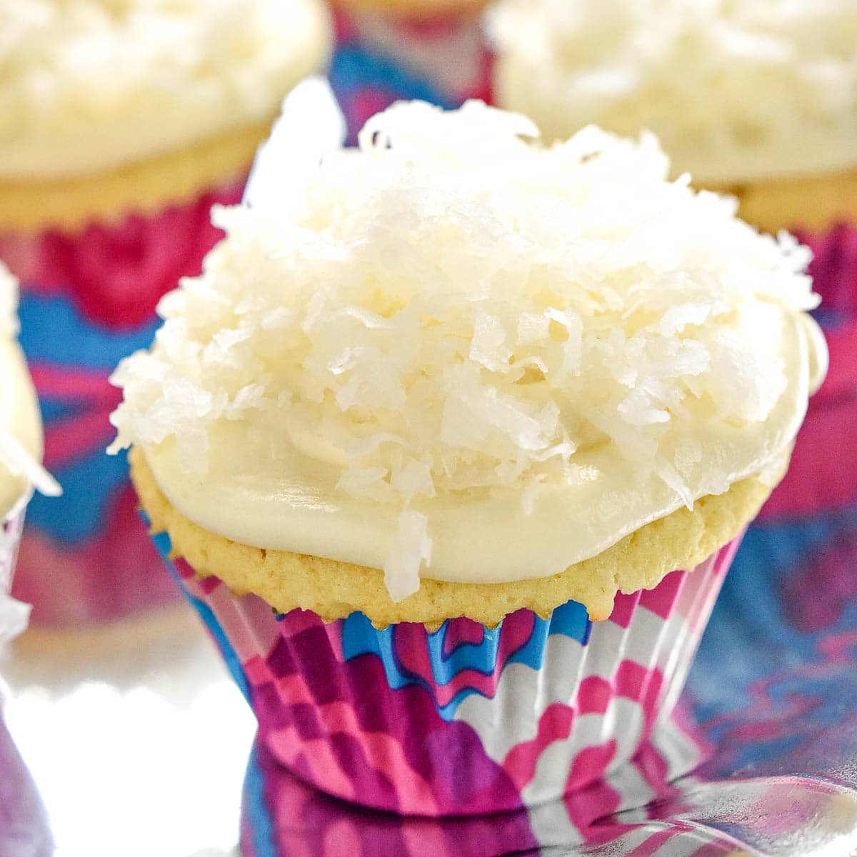 Coconut Cupcakes with cream cheese frosting and a garnish of flaked coconut.