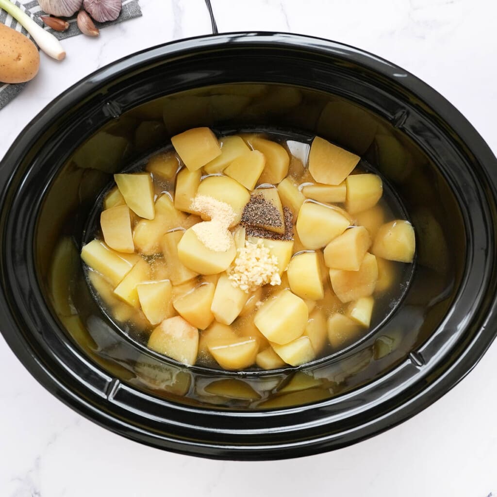 Garlic and seasonings added to crock pot.