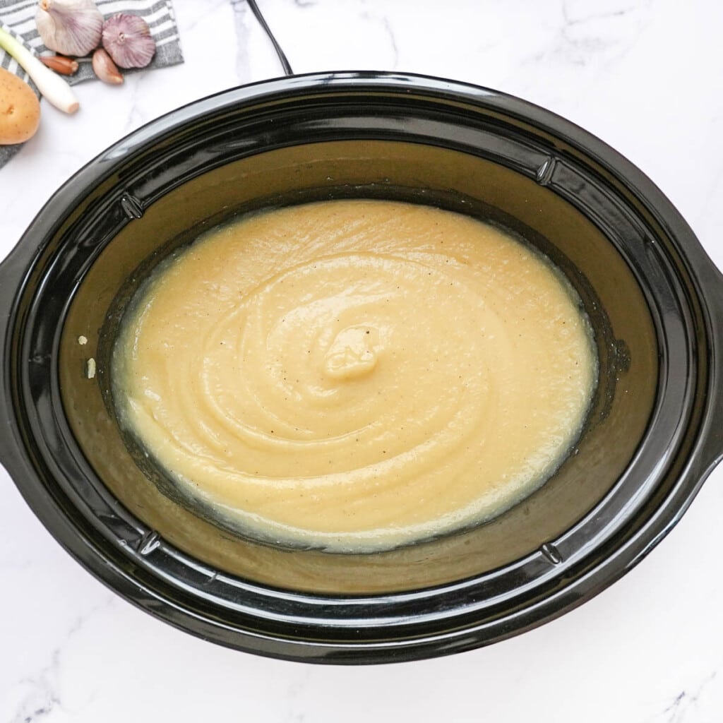 Slow cooker loaded baked potato soup pureed in crock pot.