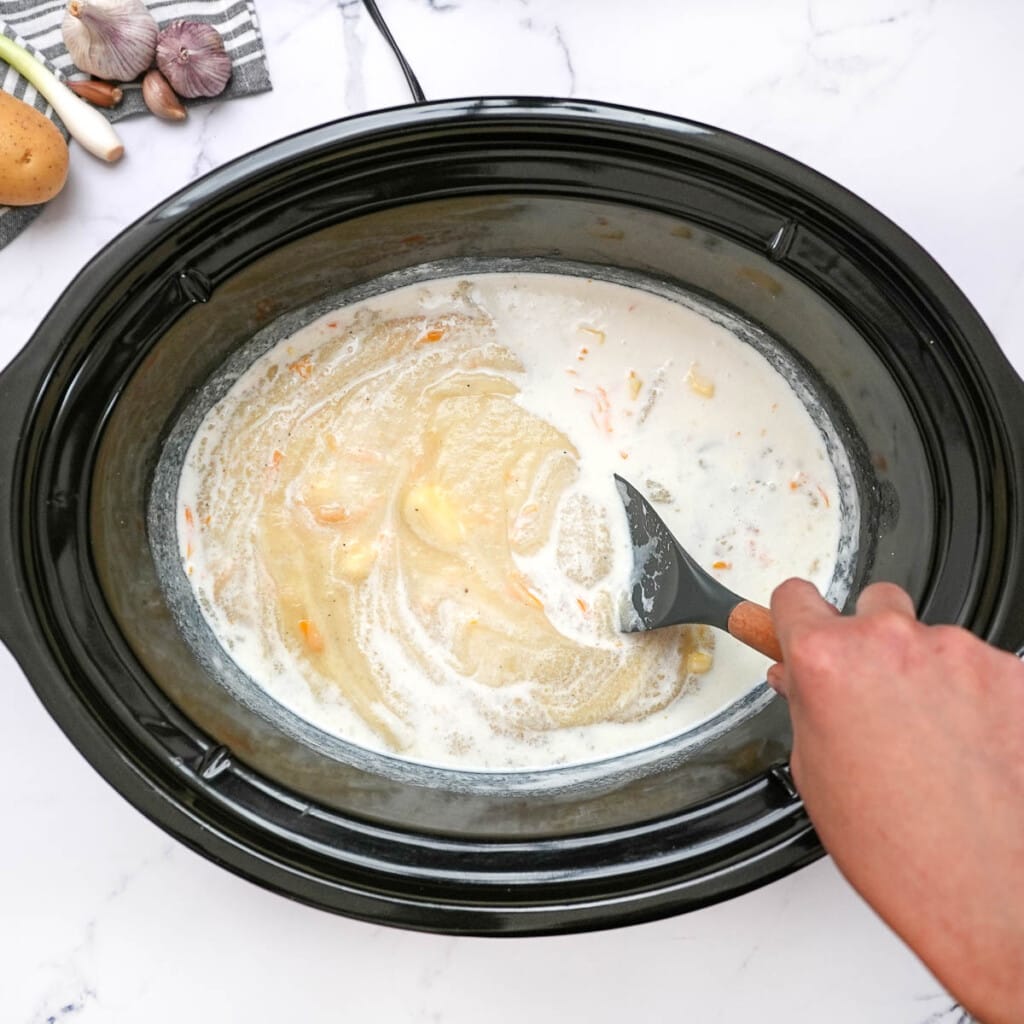 Combining pureed potatoes with other ingredients for loaded baked potato soup recipe.