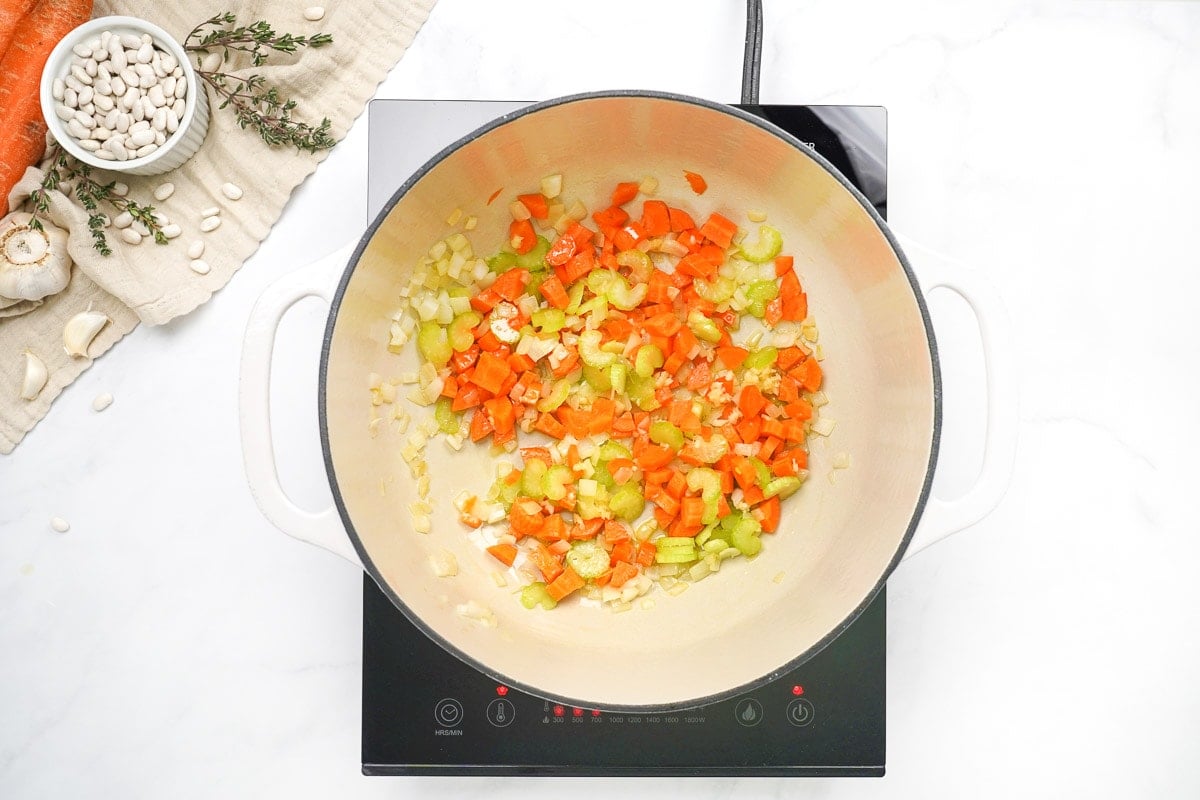 Onion, carrots, celery, and garlic sauteing in pot.