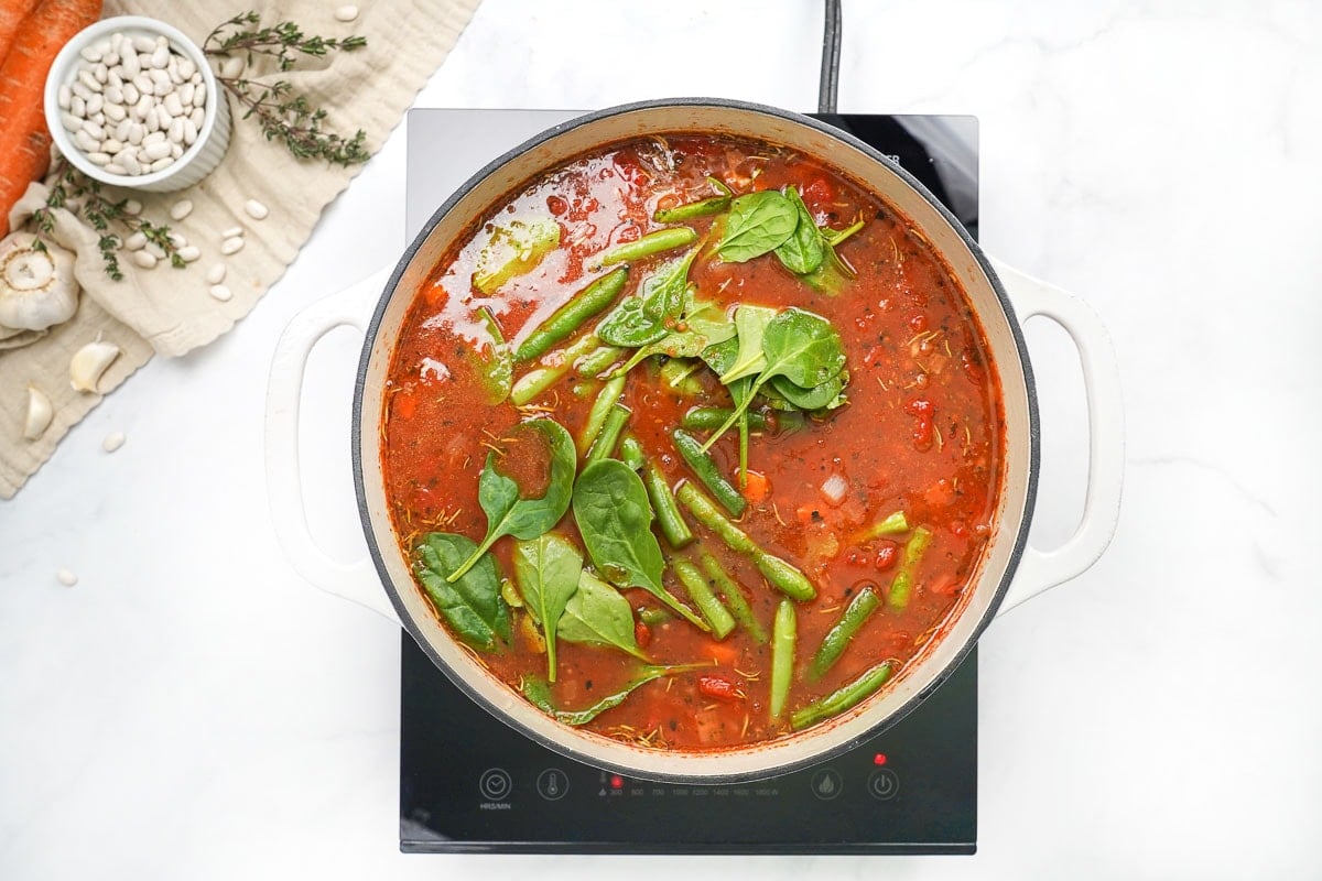 Adding the rest of the Minestrone Soup ingredients to the pot.