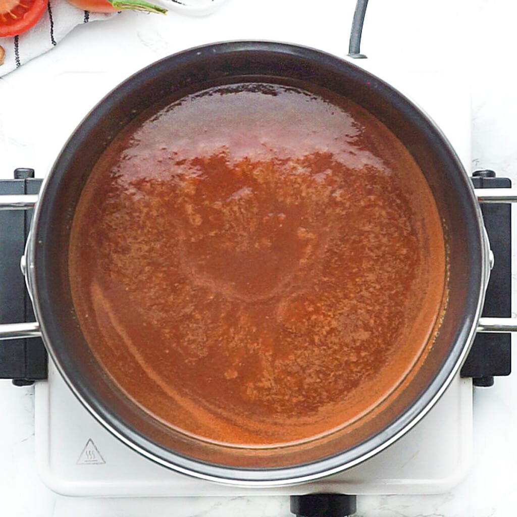 Bubbling sauce to cook Porcupine Meatballs.