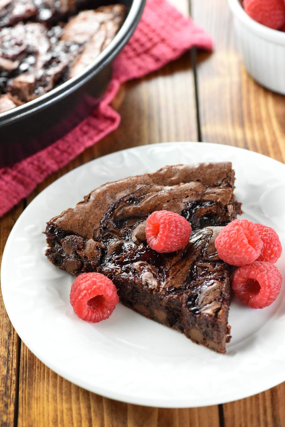 Raspberry Brownies on white plate with berries.